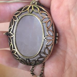 Selling a rose quartz locket necklace.